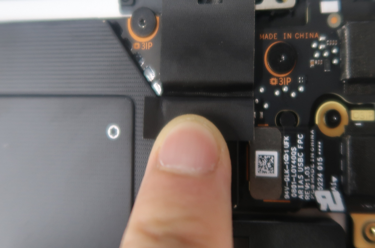 A finger pointing at a black piece of electronic equipment.
