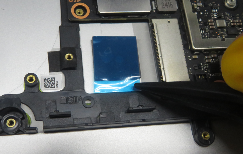 Screenshot that shows using plastic tweezers to remove the liner on the SSD thermal pad.