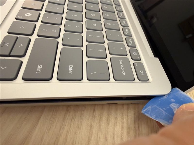 Photo of using the guitar pick to lift the top right corner of the C Cover Keyset.