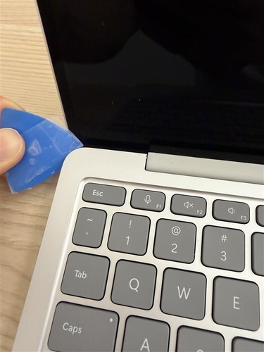 Photo that shows the guitar pick being inserted at an angle along the left side of the C Cover Keyset, using only the specified plastic tool.