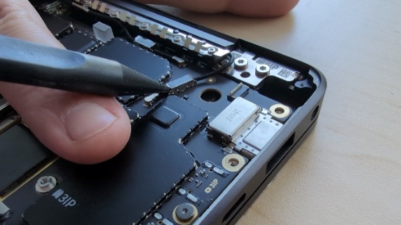 Screenshot that shows a person using a stylus to fix a device.