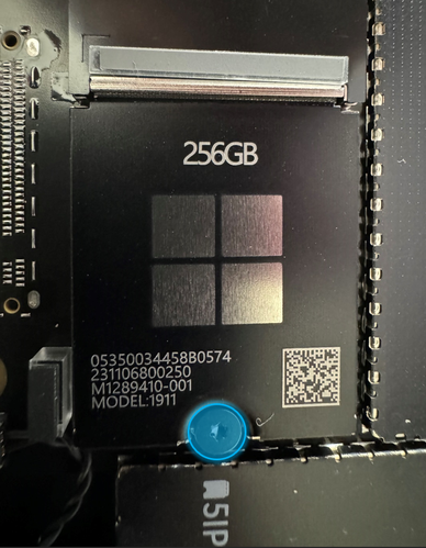 Screenshot that shows a 5IP (Torx-Plus) driver removing the screw securing the removable SSD to the motherboard.