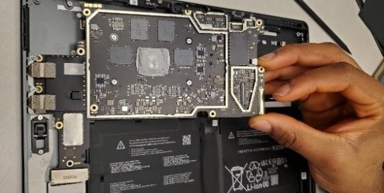 A hand holding a circuit board Description automatically generated