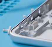 Photo that shows using a nylon spudger to push out the power and volume buttons from the enclosure.
