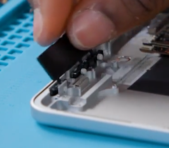 Photo that shows inserting the button clip assembly into the enclosure.