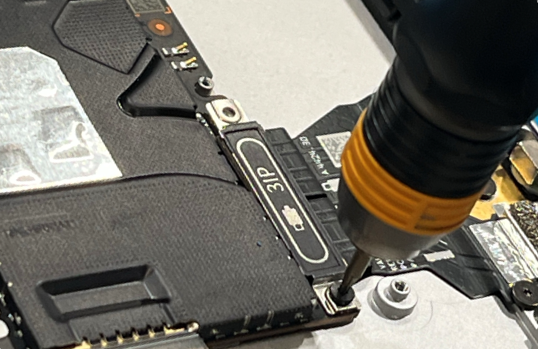 Photo that shows a 3IP screwdriver removing the USB-C bracket screw.