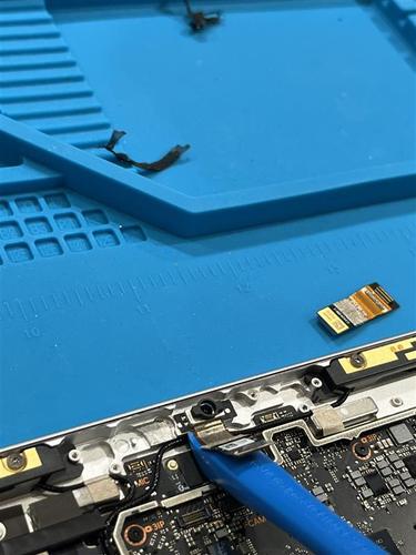 Photo that shows the internal camera area with fan cables and shielding before front camera removal.