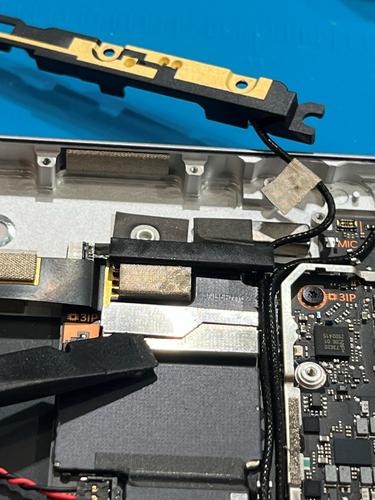 Photo that shows the T3 top shield lid and attached tape being removed using plastic tweezers.