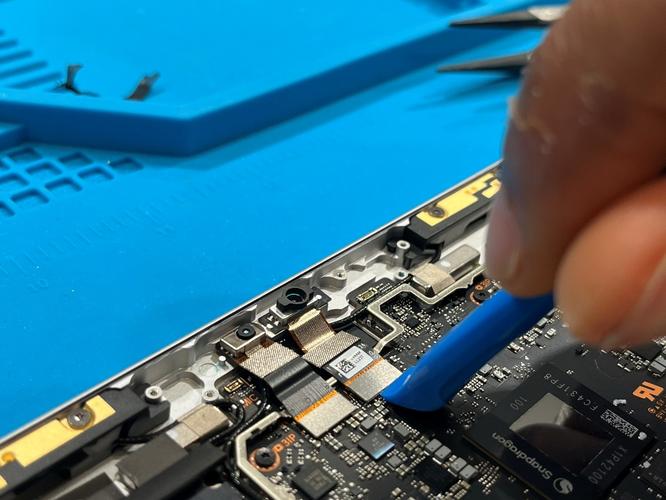 Screenshot that shows using a plastic opening tool to disconnect the front and IR camera FPC connectors from the motherboard.