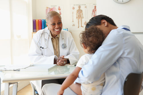 Screenshot of a woman and child consulting with a doctor.